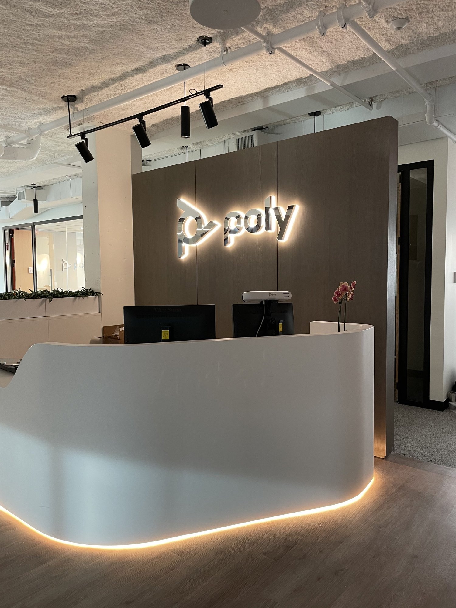 Illuminated logo above a contemporary reception desk